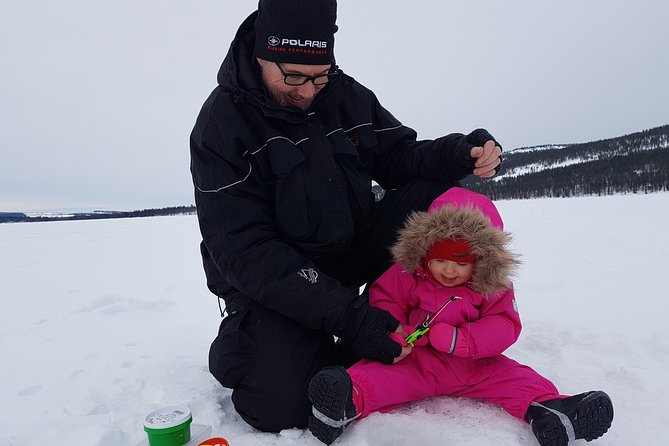 Ice fishing by car with hot beverages at Pyhä-Luosto - Drilling through the ice, one slow turn at a time