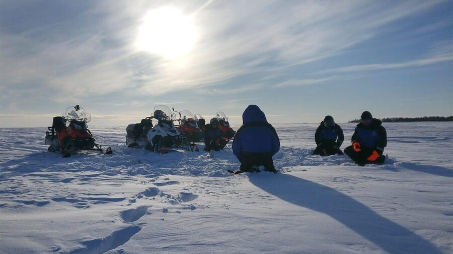 Kemi-Tornio: Ice Fishing Safari with Snowmobiles - Drilling through the ice and finding a fishing spot