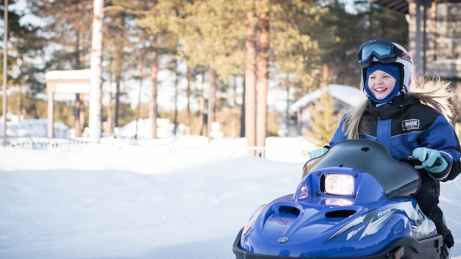 Rovaniemi: Family Snowmobile Safari with Campfire and Snacks - Adult snowmobiling through the forest